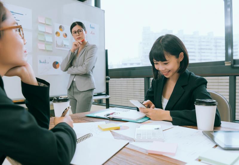 A woman looking at her phone during a job interview 