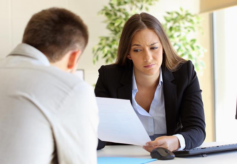 Woman looking suspiciously at a resume wondering if they contain any white lies. See why they matter.