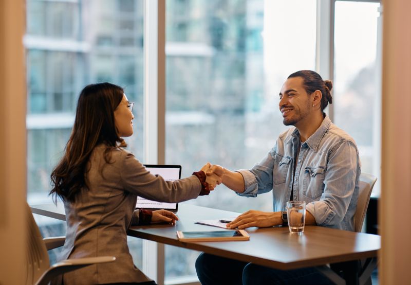 Man and woman shaking hands during an interview
