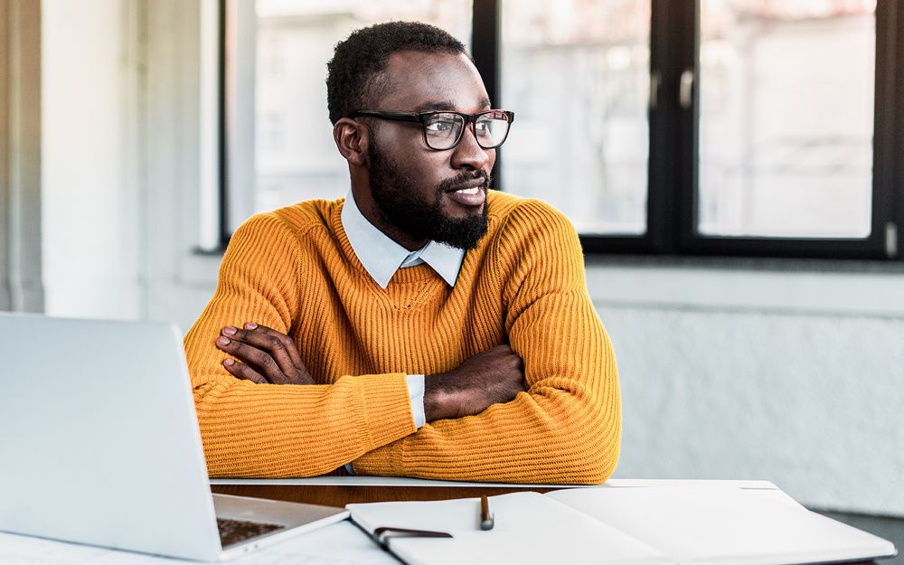 Un homme qui a obtenu un travail de bureau grâce à l’agence de placement TalentWorld a l’air confiant et satisfait.