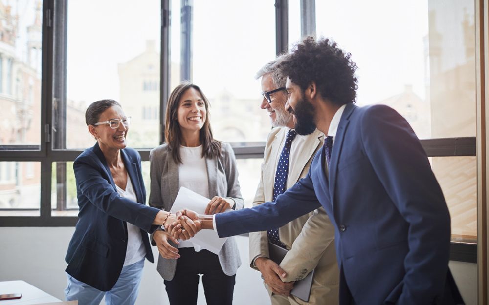 A new executive is happily being welcomed to the company after being headhunted by TalentWorld, a staffing agency.