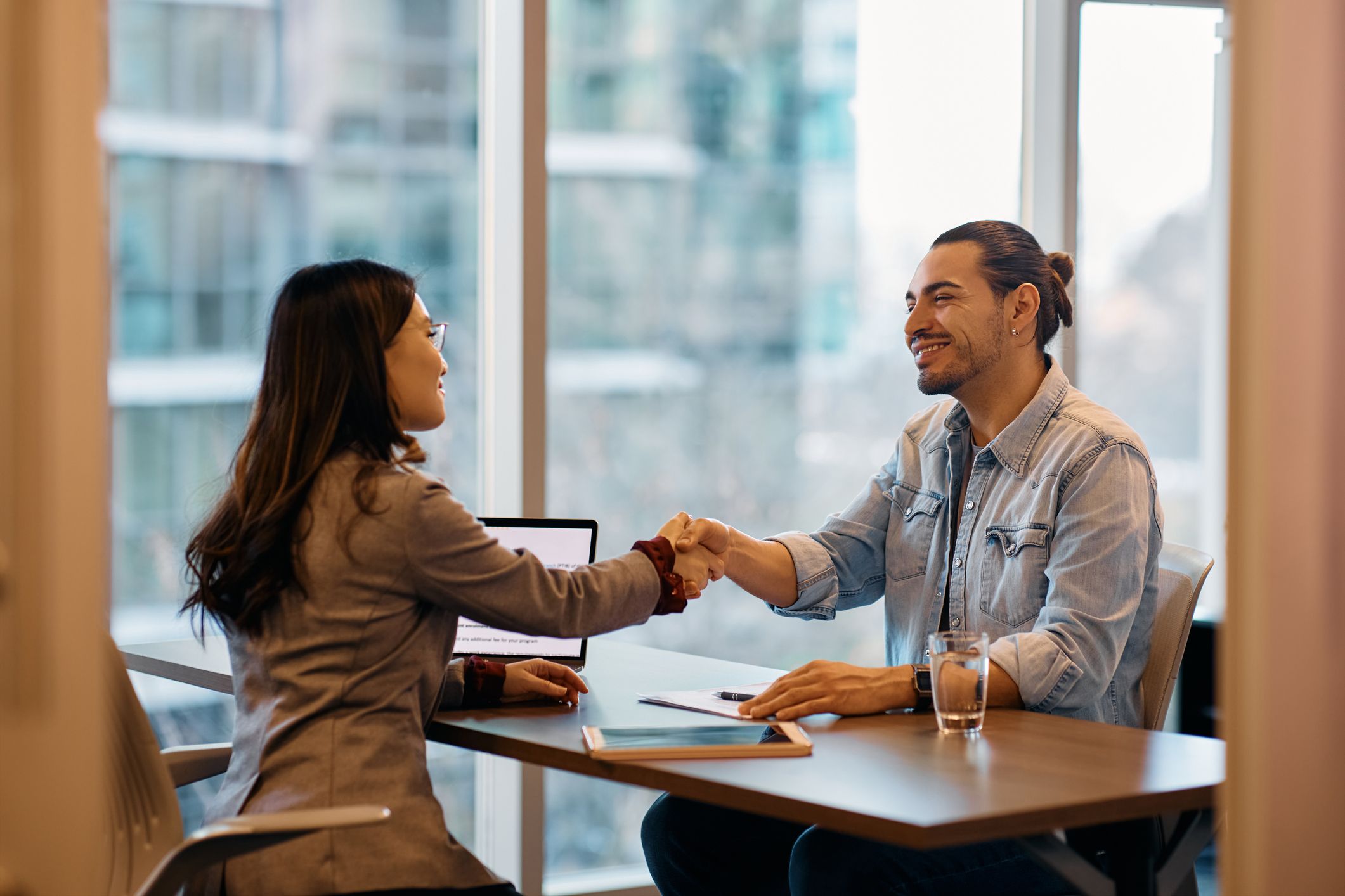 Man and woman shaking hands during an interview
