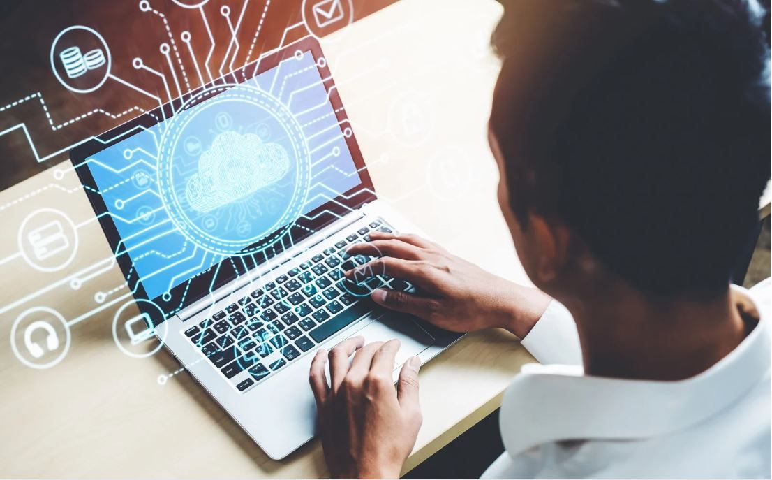 Individual typing on laptop with graphics coming off of the computer screen.